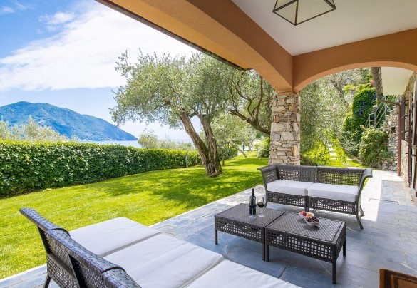 Il portico allestito a salotto esterno si affaccia sul prato con un’incantevole vista - Villa Baia Blu