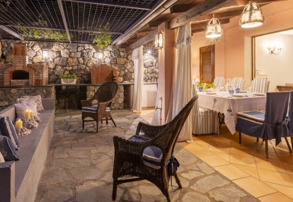 The dining area under the veranda, also equipped with a small kitchen, barbecue area and brick sofas - Villa Bambù