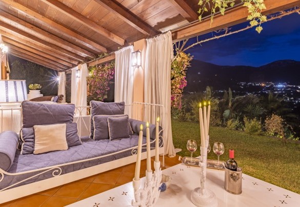 The front veranda of the house in the evening lights with a view of the illuminated village - Villa Bambù