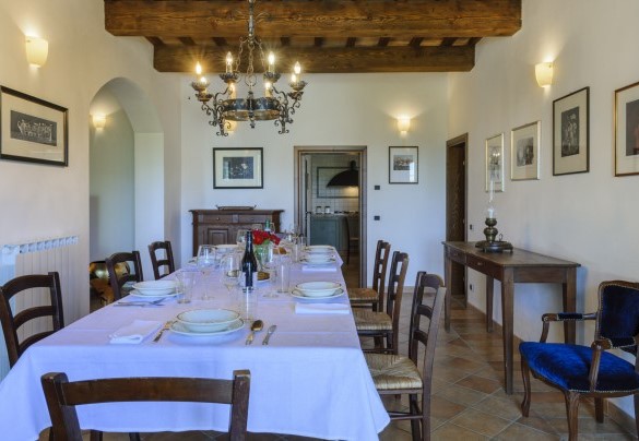 Sala da pranzo con accesso diretto al giardino attraverso una porta finestra – Villa Banci 