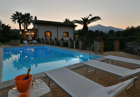 La zona piscina di sera - Villa Biddizza