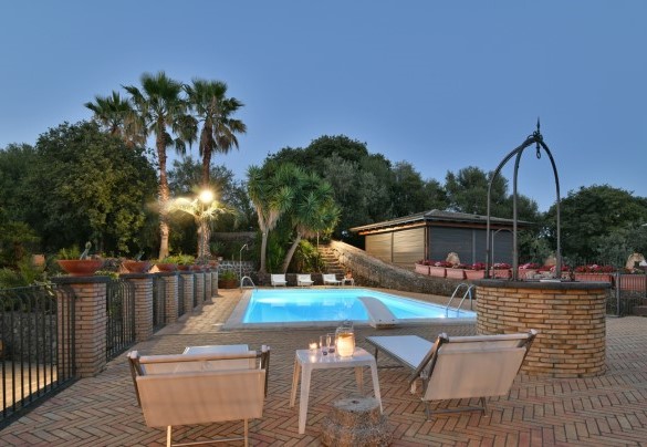 La zona piscina di sera - Villa Biddizza