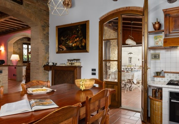 La cucina abitabile in muratura con camino (ornamentale) con accesso diretto, tramite porta finestra, al terrazzo coperto – Villa Binetti