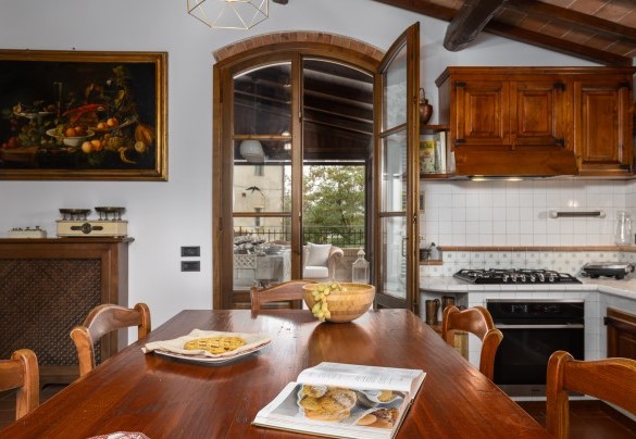 La cucina abitabile in muratura con camino (ornamentale) con accesso diretto, tramite porta finestra, al terrazzo coperto – Villa Binetti
