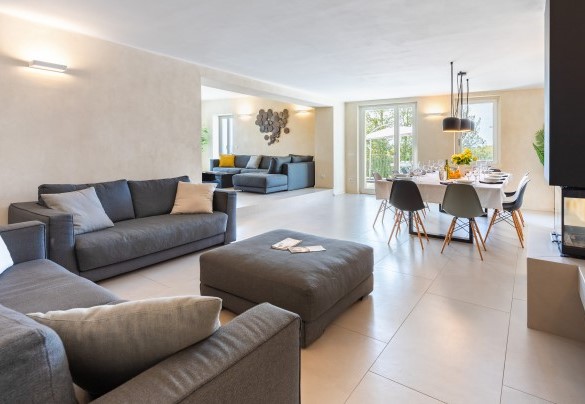 The open-plan living area, that includes two areas and the dining table with an adjoining fireplace, communicates with a large terrace and with the wide kitchen - Villa Boemia