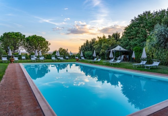 La piscina immersa nel verde al tramonto - Villa Borgo San Pietro 