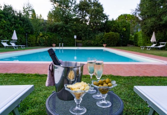 Attorno alla piscina un vasto solarium attrezzato per il relax con lettini, ombrelloni e area salotto  - Villa Borgo San Pietro 