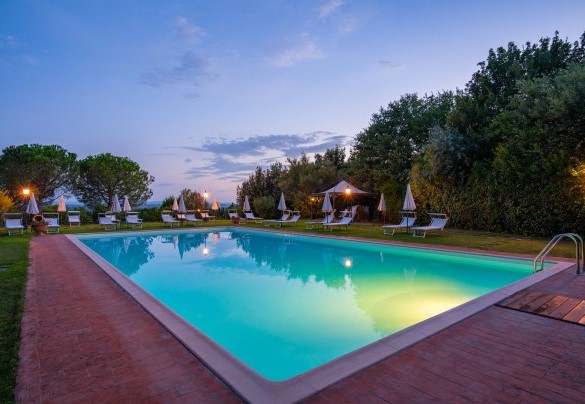 La piscina illuminata al crepuscolo con area solarium - Villa Borgo San Pietro 