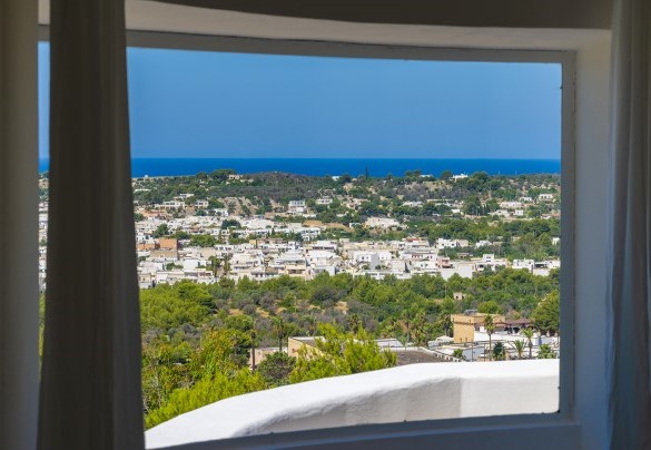 The main entrance leads to the upper floor with a large living area furnished with a spectacular dining table and sofas placed in front of large windows that frame the boundless panorama - Villa Calypso