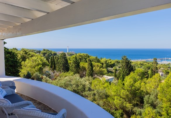 On the top floor, outside the living area, is the covered outdoor dining area furnished with a large table and sitting area; from here a few steps lead to the solarium and the panoramic swimming pool – Villa Calypso