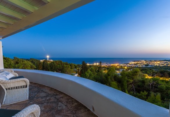 On the top floor, outside the living area, is the covered outdoor dining area furnished with a large table and sitting area; from here a few steps lead to the solarium and the panoramic swimming pool – Villa Calypso