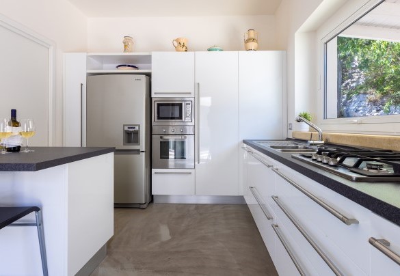 The living room leads, on the left, to the modern, fully-equipped kitchen with pantry equipped with laundry  - Villa Calypso