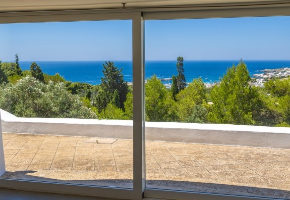 A large window acts as the entrance to the lower floor framing the view - Villa Calypso