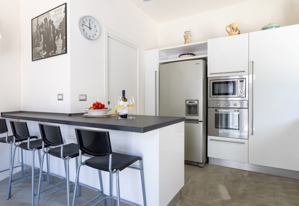 The living room leads, on the left, to the modern, fully-equipped kitchen with pantry equipped with laundry  - Villa Calypso