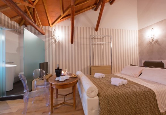 Abaino suite on the upper floor characterized by glass walls equipped with en suite bathroom with shower and attics with splendid wooden beams. Villa Capozza