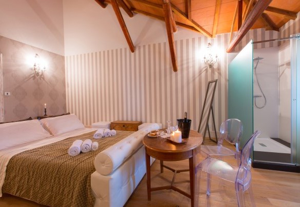 Abaino suite on the upper floor characterized by glass walls equipped with en suite bathroom with shower and attics with splendid wooden beams. Villa Capozza
