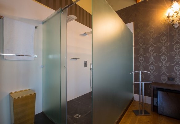 Unique and elegant en-suite bathroom brown with glass walls with double shower. Villa Capozza
