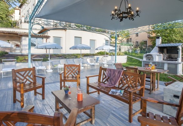 Gazebo furnished with sofas and barbecue area with wood-fired oven, next to the swimming pool – Villa Cappelletti