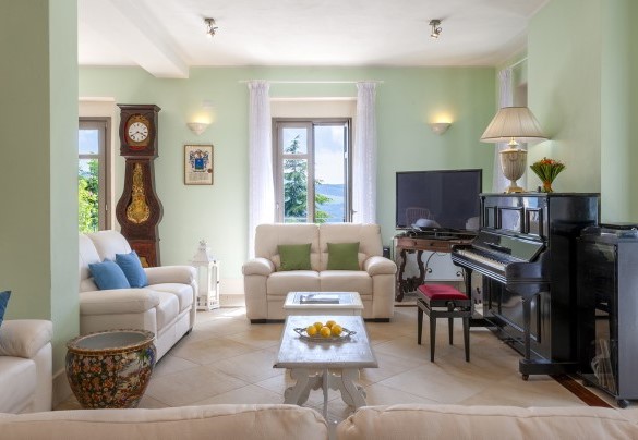 Living area furnished with sofas, TV and piano - Villa Cappelletti
