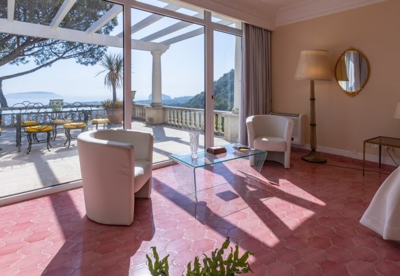The suite with master bedroom with a glass wall overlooking the entire Gulf and terrace with table and chairs – Villa Carina