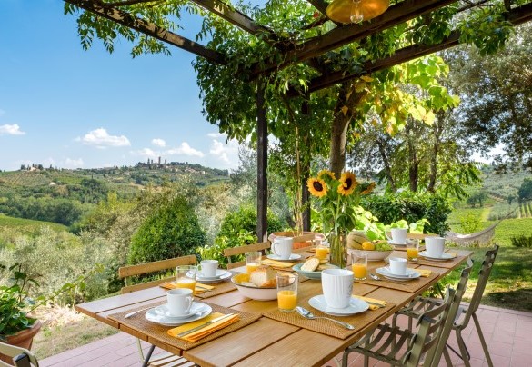 La pergola davanti al salotto/sala da pranzo, vestita di begonie, vite americana e glicini è la cornice ideale in cui fare colazione- Villa Caterina