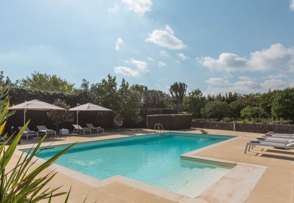 La zona piscina è delimitata da muretti a secco in pietra lavica - Villa Kimia