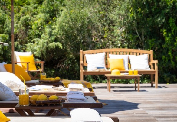 Il solarium della piscina ospita lettini e ombrelloni – Villa Corallina