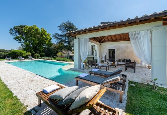 Il portico con lettini e zona living a bordo piscina - Villa Corte Sant’Anna