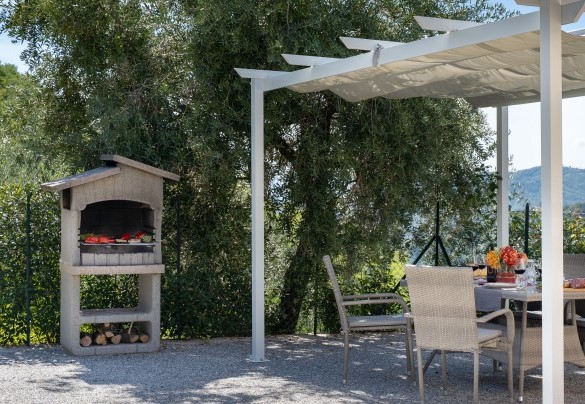 The outdoor dining area shaded by a gazebo, with table, chairs and brick barbecue - Villa Cristina