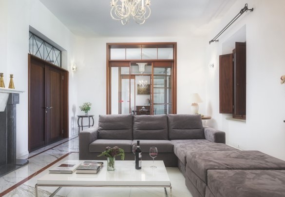 Living room on the first floor with tv and ornamental fireplace and fine furnishings – Villa Croci 