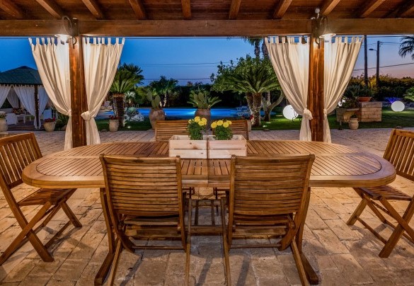 Il portico è attrezzato con un elegante tavolo e sedie il legno - Villa Cutrera