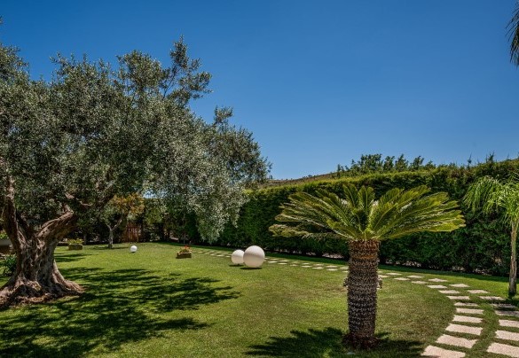 Il parco include vialetti con la ghiaia bianca delimitati dalla pietra chiara della zona - Villa Cutrera