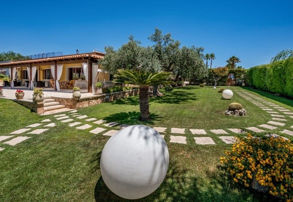 Il parco include vialetti con la ghiaia bianca delimitati dalla pietra chiara della zona - Villa Cutrera