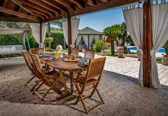 Il portico è attrezzato con un elegante tavolo e sedie il legno - Villa Cutrera