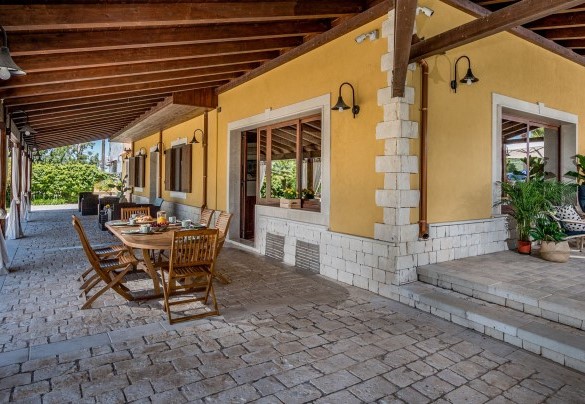 Il portico è attrezzato con un elegante tavolo e sedie il legno - Villa Cutrera