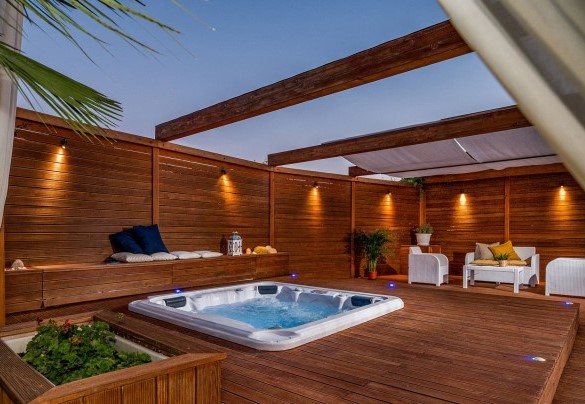 Una zona sopraelevata pavimentata in legno ospita la jacuzzi - Villa Cutrera