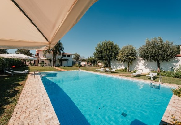 Lined in turquoise ceramics which give the pool a wonderful colour, creating a perfect union with the blue sky, the lawn and surrounding plants, it has chlorine purification and a steel ladder for access to the water - Villa D’Aquino
