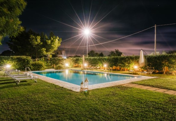 Calm waters reflected under the night sky, the illuminated pool invites a moment of peace and reflection beneath the stars - Villa D'Aquino