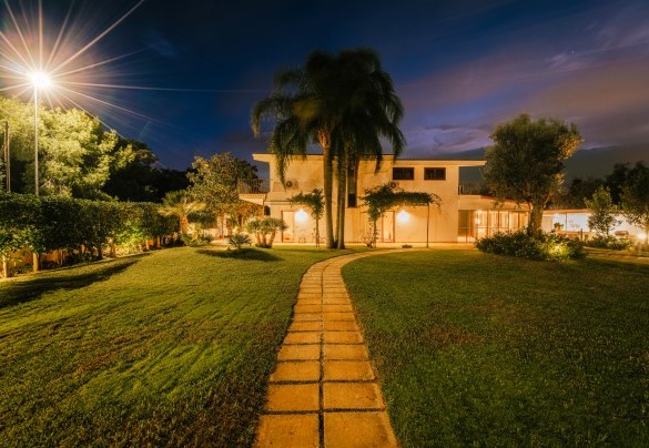 The park is covered mainly by lawn that surrounds the swimming pool and stretches up to the glass living room and the lateral relaxation area - Villa D’Aquino