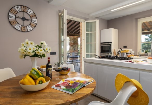 La cucina con isola centrale, che accede sull’esterno mediante porta finestra – Villa Dada
