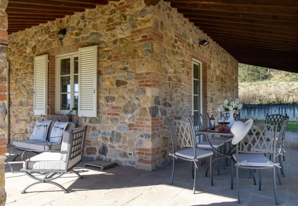 Il portico che si sviluppa su due lati e che ospita la zona pranzo esterna per i momenti di convivialità e un salottino per immergersi nella natura e nella tranquillità – Villa Dada