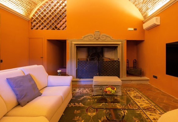 Il salone con TV e camino (ornamentale) al piano terra inferiore  - Villa De Cerchi