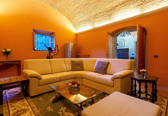 Il salone con TV e camino (ornamentale) al piano terra inferiore  - Villa De Cerchi