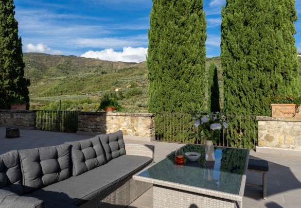 La terrazza con salottino con una vista sulle colline, delimitata da un parapetto in parte in pietra e in parte con ringhiera in ferro. - Villa De Cerchi
