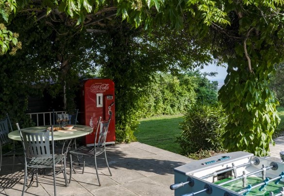 Il portico, adiacente alla cucina, è allestito a zona pranzo con tavoli e sedie - Villa degli Ulivi 