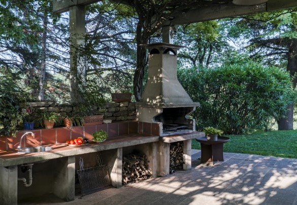 A pochi passi dal portico allestito a zona pranzo si trovano il barbecue ed il tavolo da ping pong – Villa degli Ulivi 
