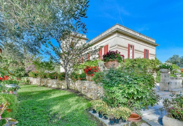 La villa vista dal rigoglioso giardino in stile mediterraneo estremamente curato– Villa dei Glicini