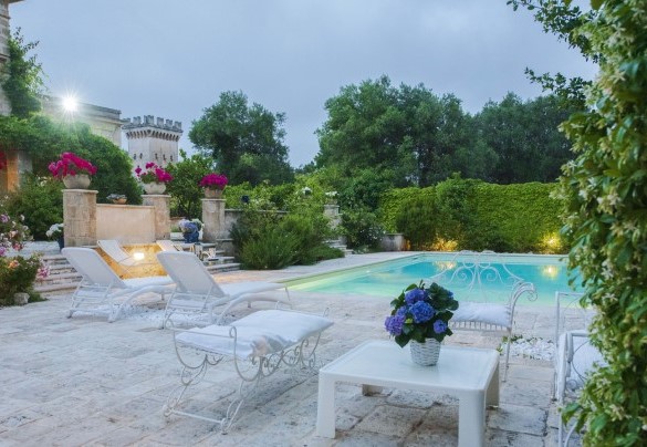 L’area piscina arredata con sdraio e lettini  è illuminata di sera- Villa dei Glicini