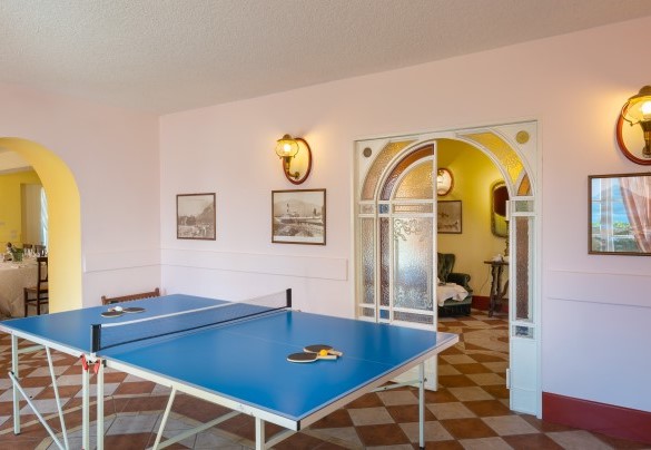 sala giochi attrezzata con un tavolo da ping pong, un divano e una varietà di giochi per bambini di tutte le età – Villa Alba del Lario