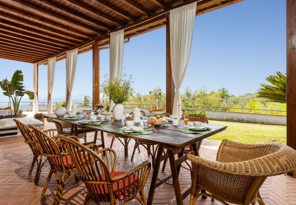 La zona pranzo esterna, allestita con tavolo e sedie - Villa Desiderio